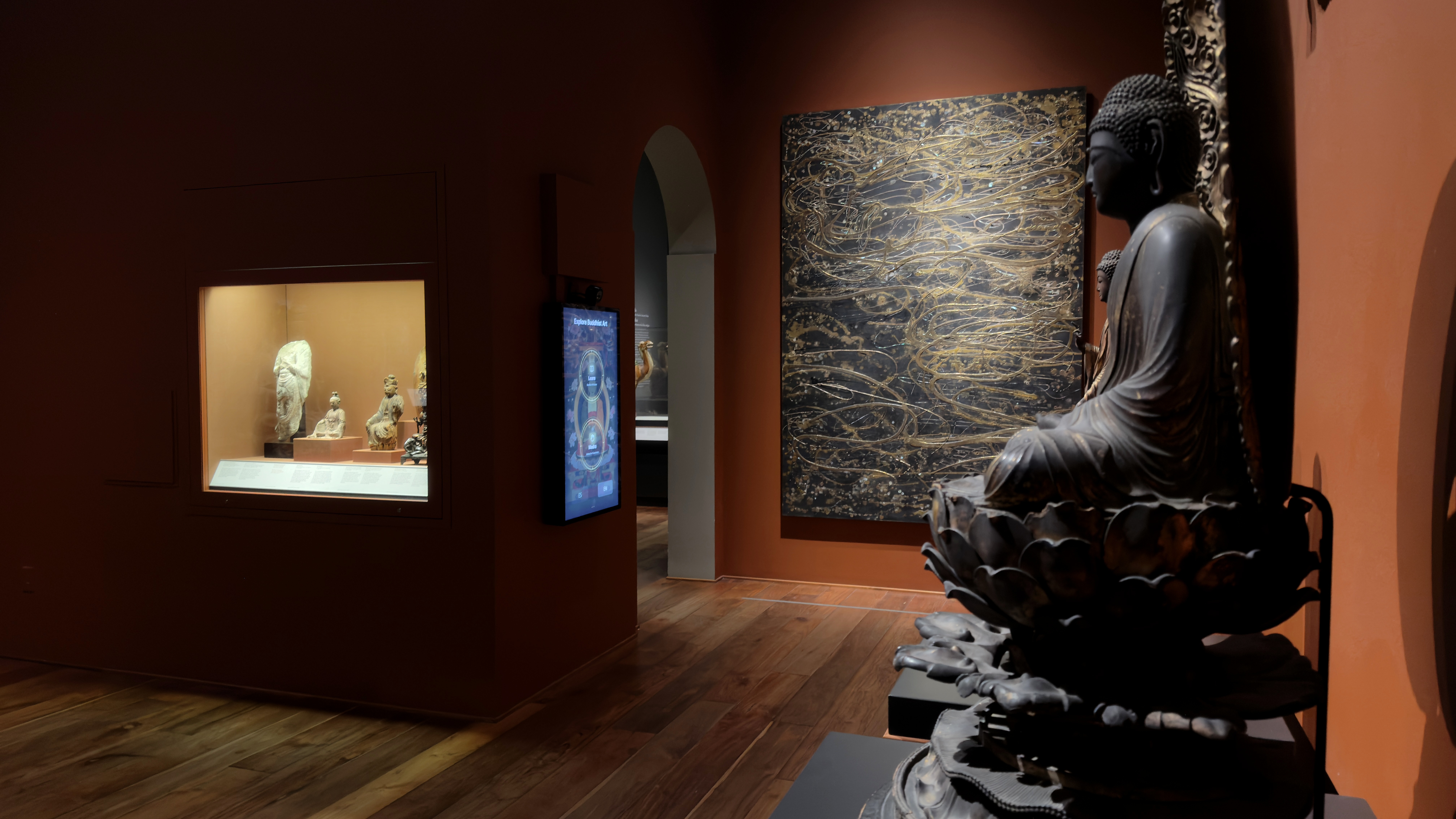 Installation view: the station embedded in the Temple Room's viewing sequence, between the gallery's collection case, the gold-lacquer painting, and the seventeenth-century Japanese Amida Buddha sculpture in the foreground.
