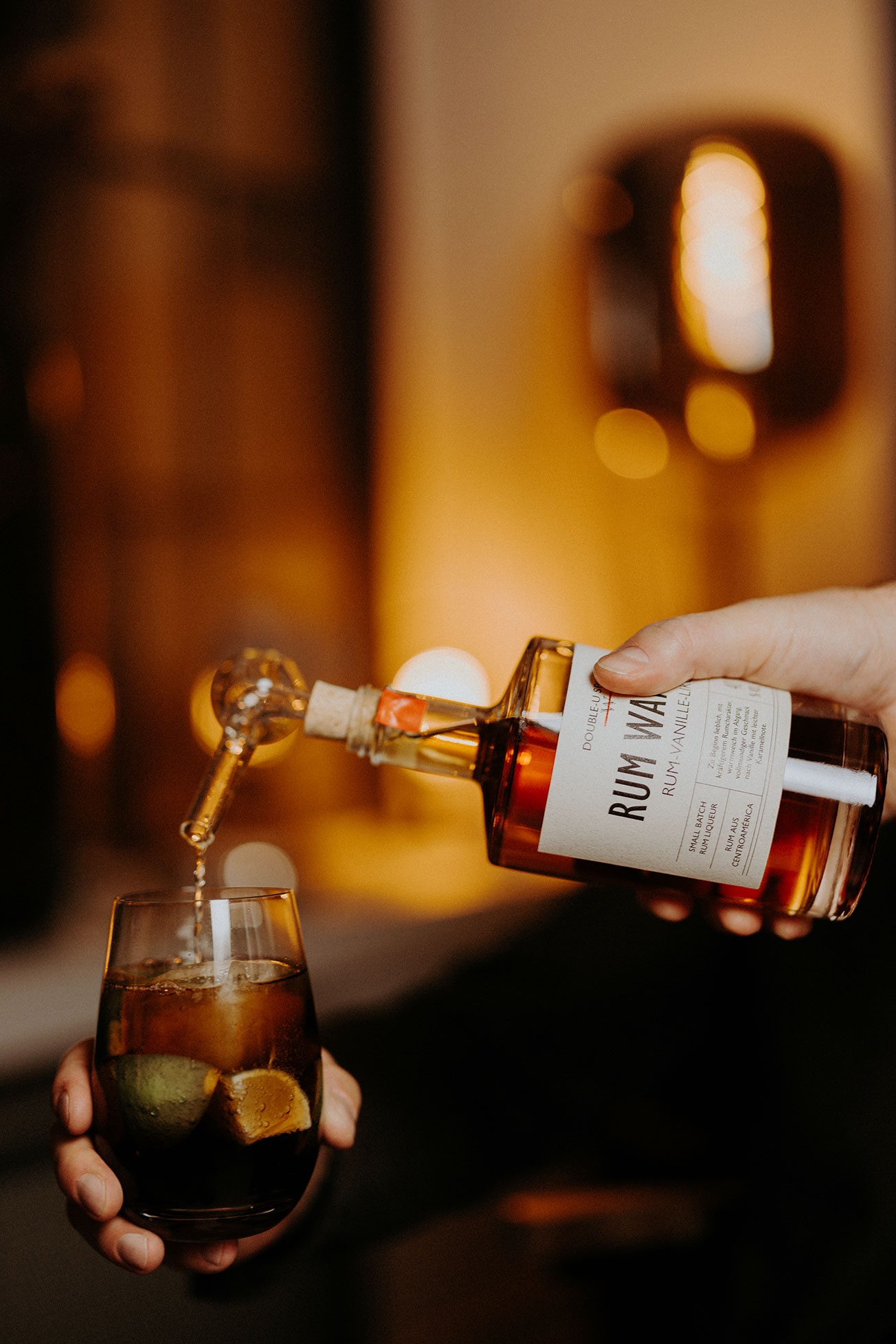 Rum Wanilla von Double-U Spirits wird in ein Glas mit Eis eingeschenkt