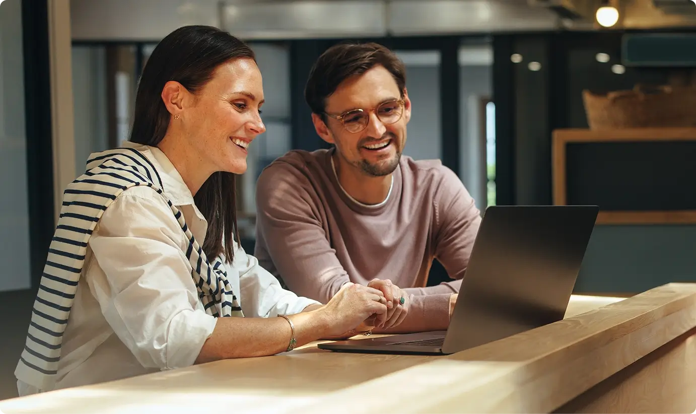 A man and woman in an office on a video call