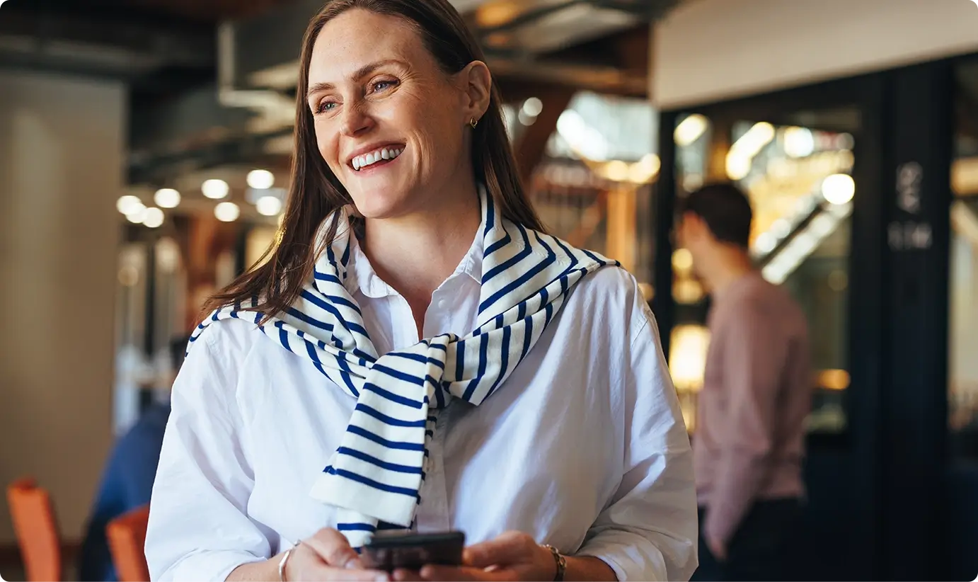 Woman in an office smiling on her mobile phone
