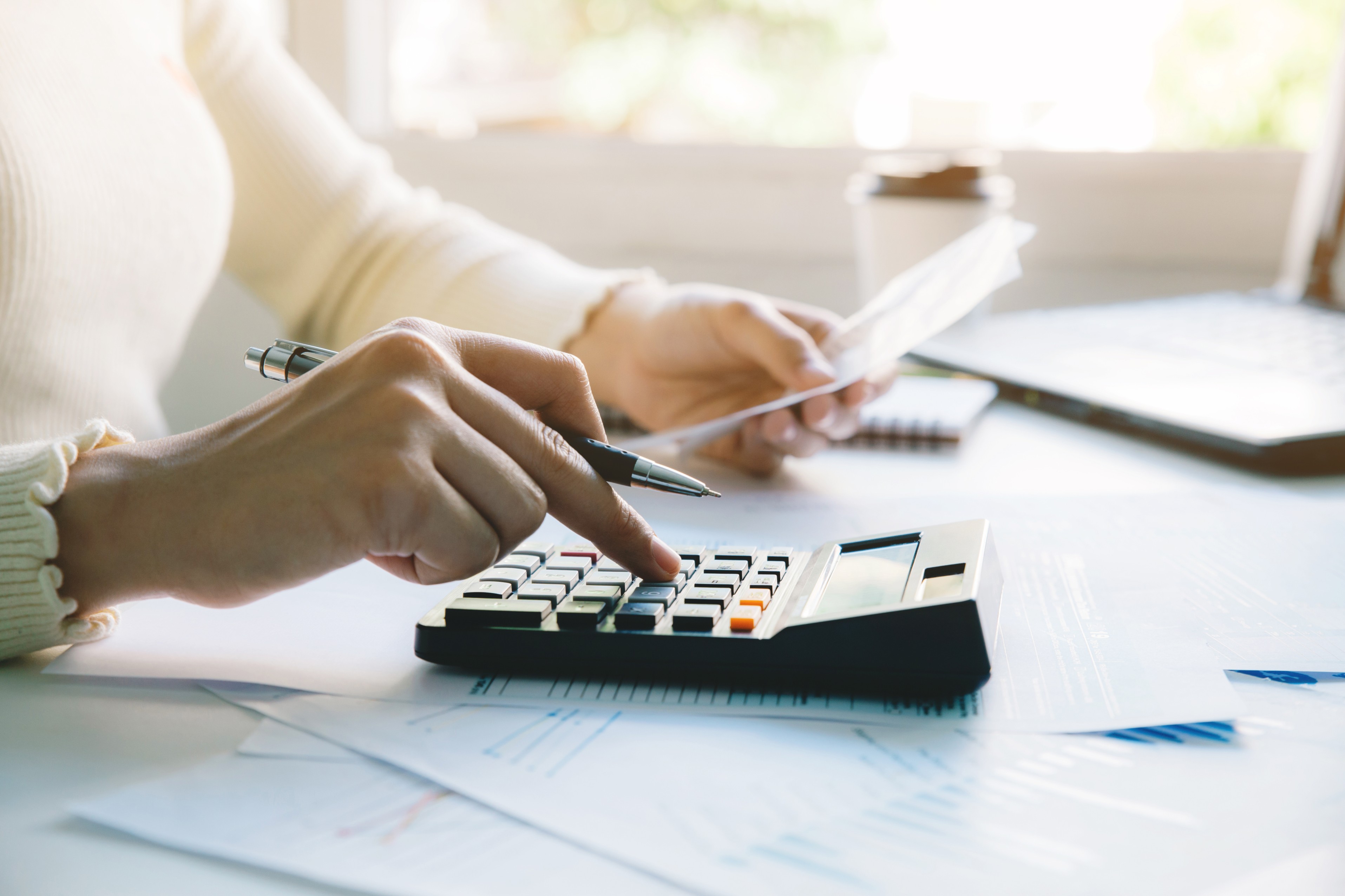 smartly dressed female using a calculator
