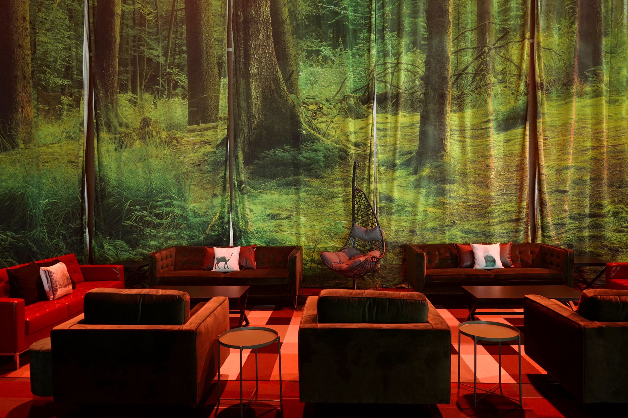 Forest-inspired graphics across fabric backdrops and lounge seating at Rise Gala.