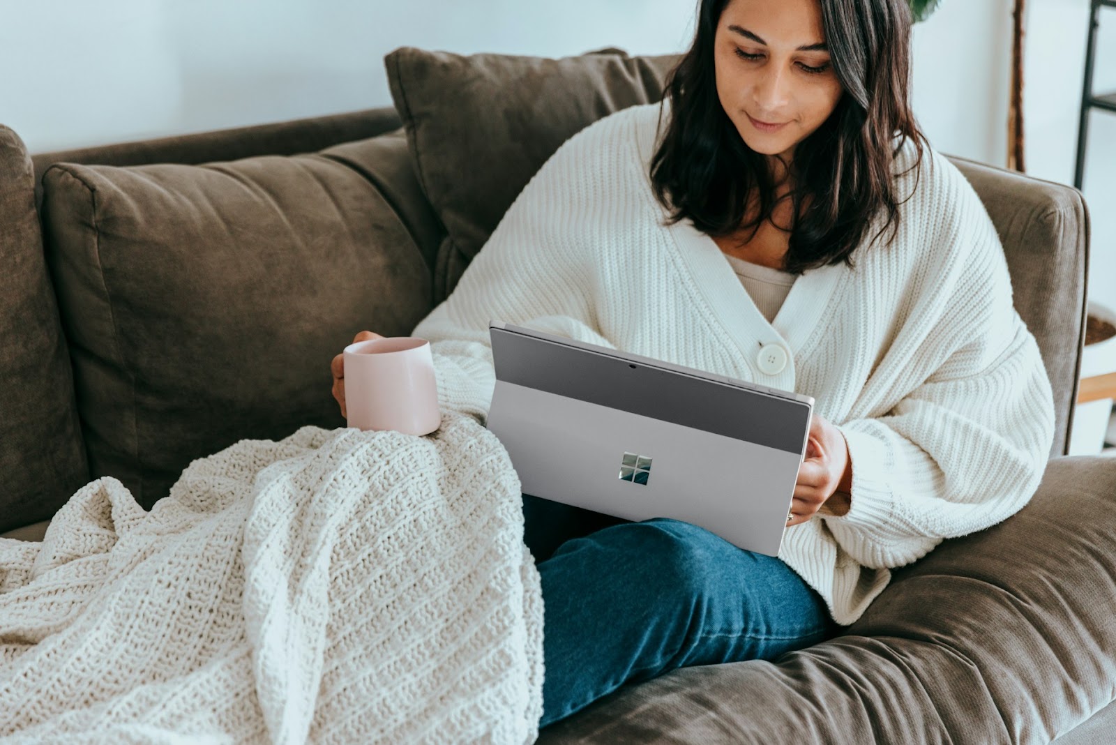 A woman with a tablet on a couch