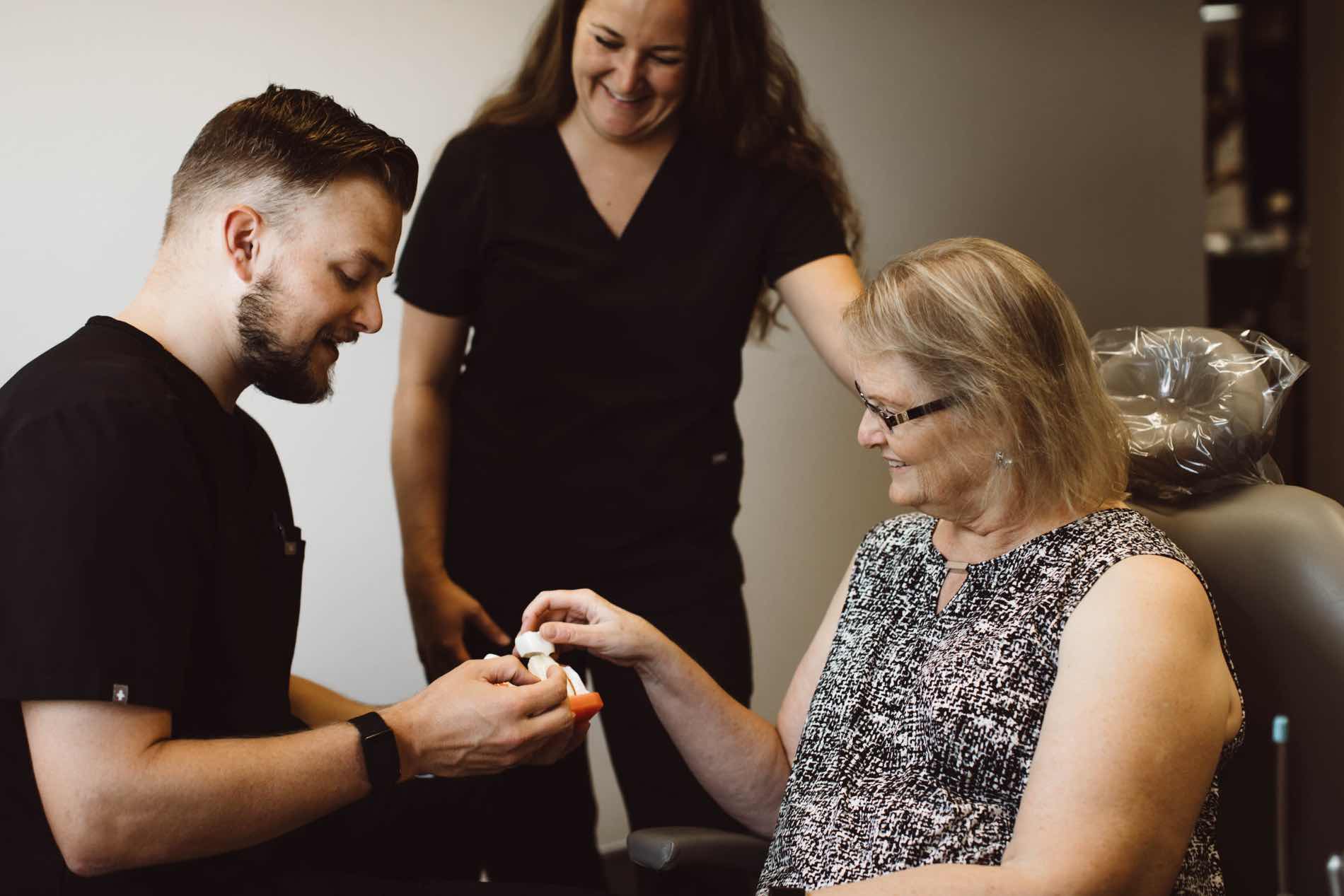 Photo of Dr. Johnson showing a model to a patient in the dental chair