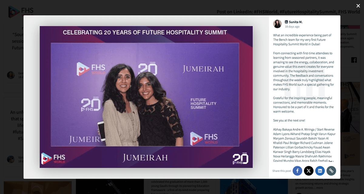 Two attendees smiling and posing together in front of a branded Future Hospitality Summit backdrop celebrating 20 years, with FHS World and Jumeirah logos visible.