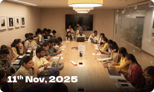Group of people seated around a large conference table engaged in a meeting, with text '11th Nov, 2025' in the bottom left corner.