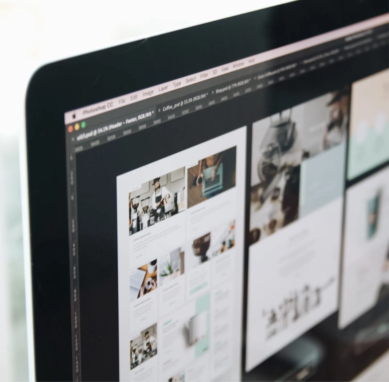 Computer screen displaying a Photoshop CC workspace with a web design project featuring images and text blocks.