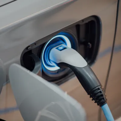 An electric car connected to a charging station at a commercial property.