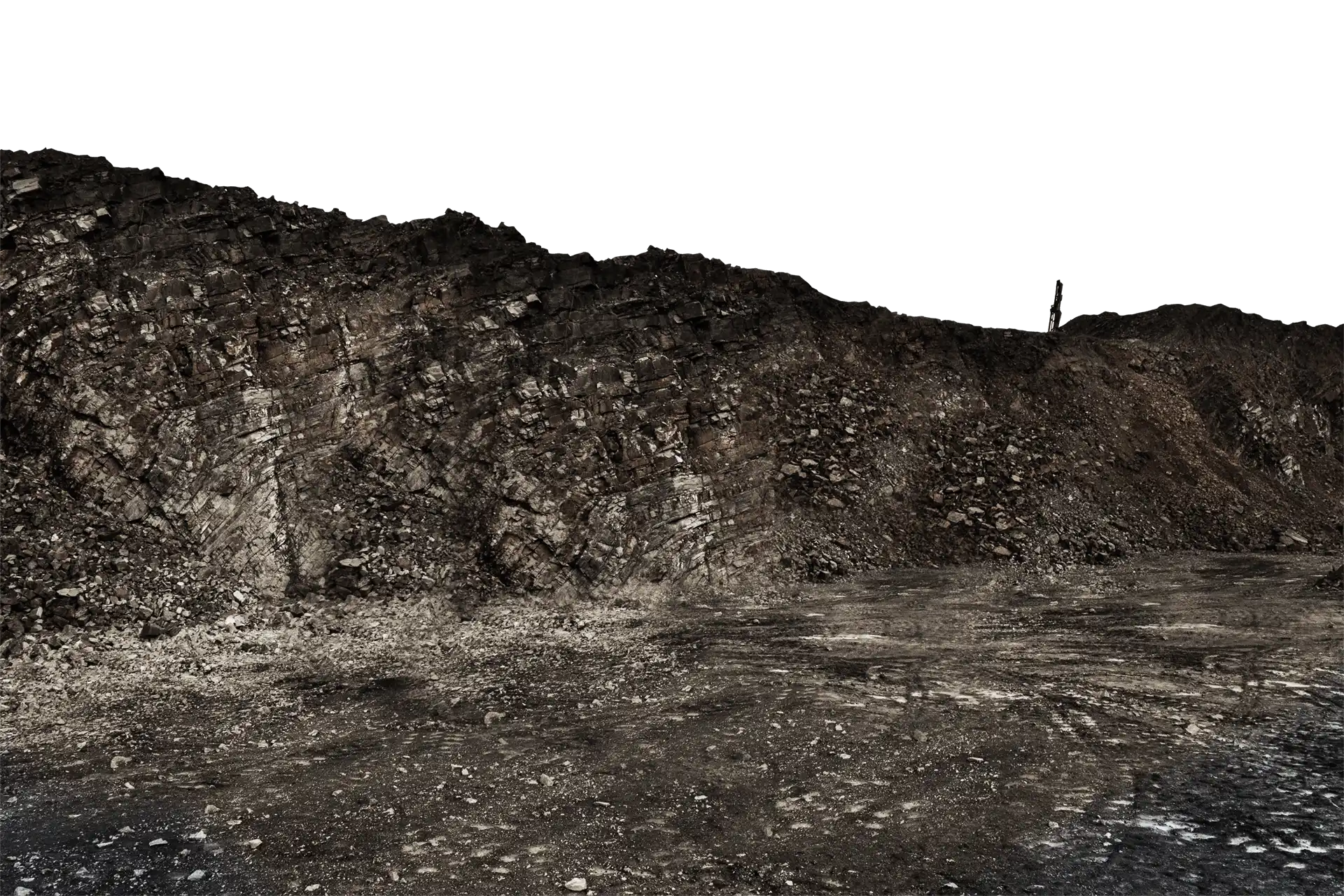 Dark grey rock quarry with a levelled base.