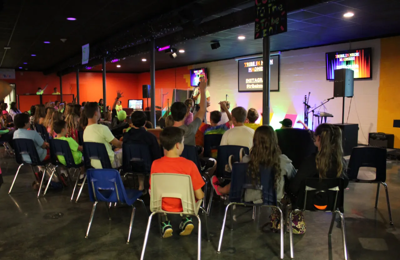 group of kids having a lesson and raising their hands at First Baptist Church- Indian Trail