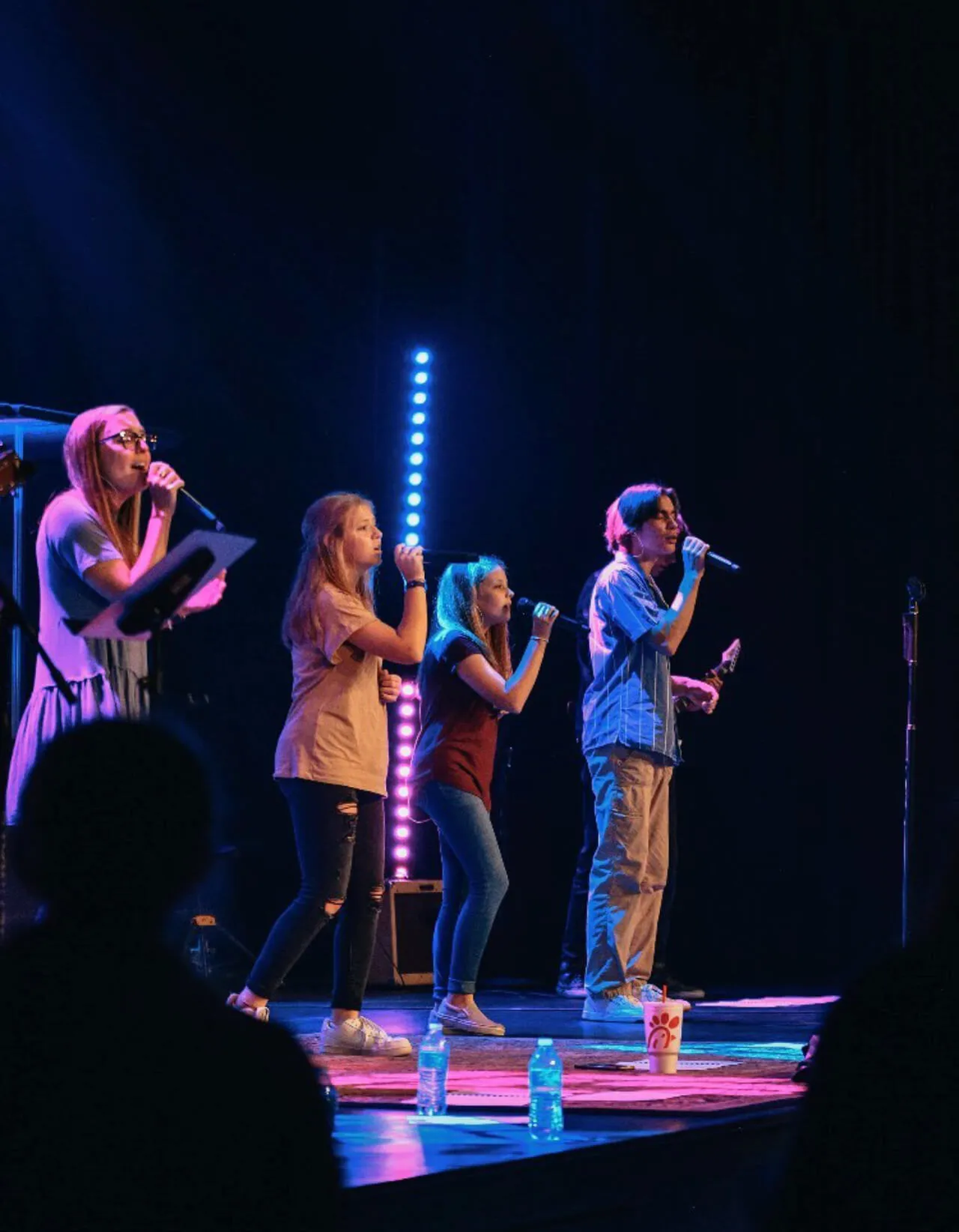 three girls and man singing and performing on stage at First Baptist Church- Indian Trail