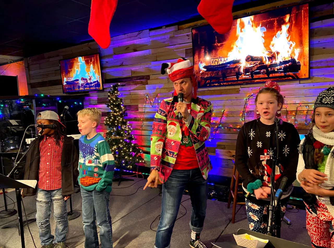 a man with Christmas attire performing with kids at First Baptist Church- Indian Trail