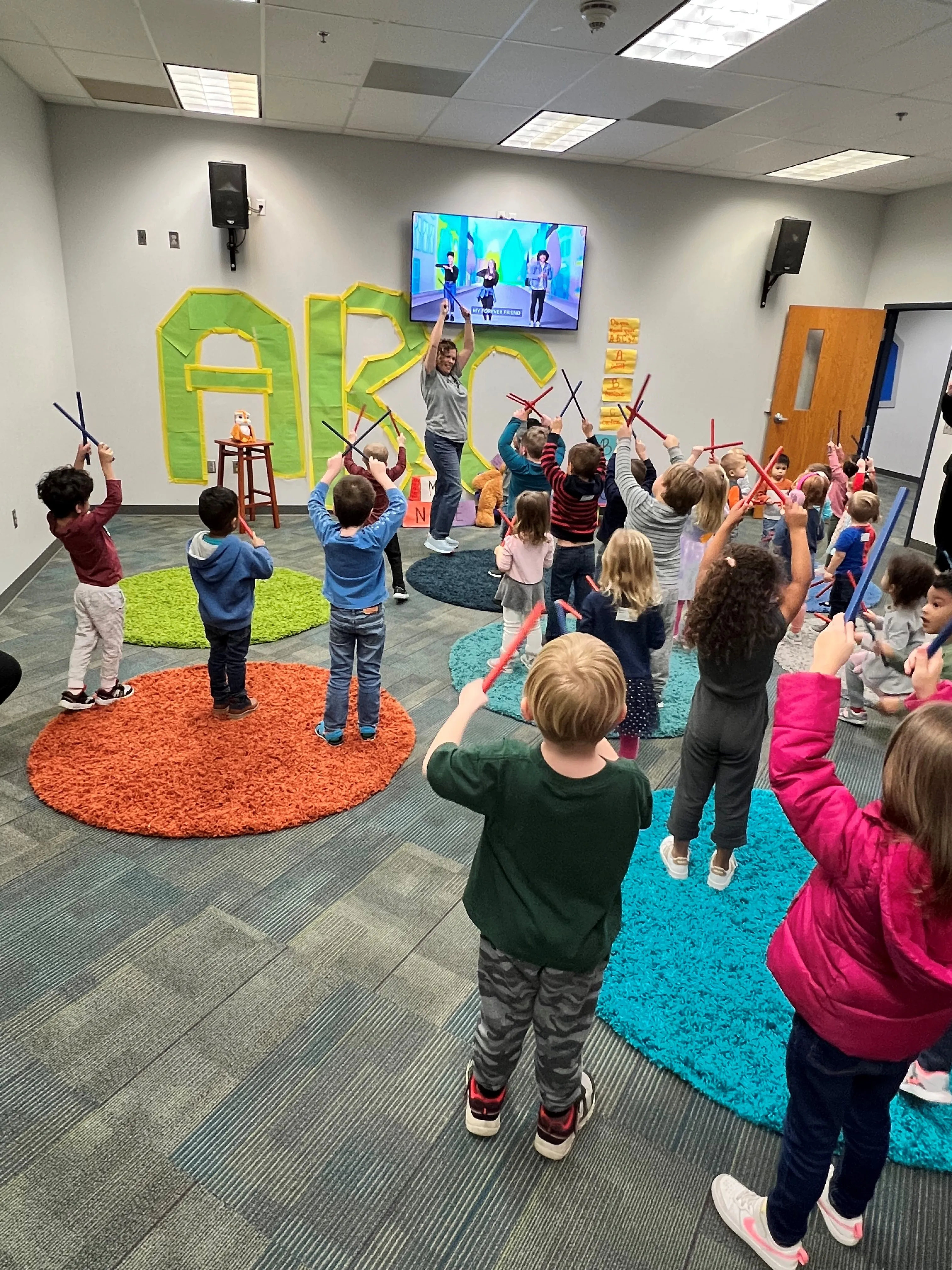 teacher with kids holding sticks at First Baptist Church- Indian Trail