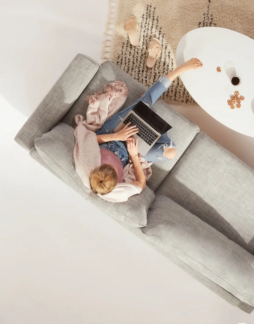 Woman working on her laptop on a sofa