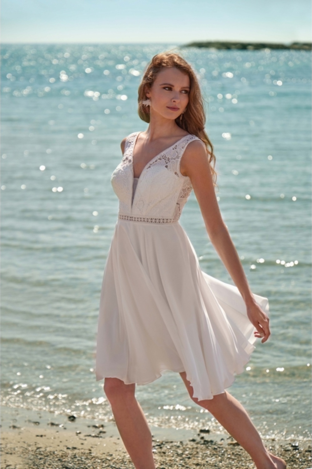 Très jolie robe de mariée courte. Bustier en dentelle, et bretelles, décolleté féminin et dos nu. Idéale pour un mariage civil ou un brunch de mariage.