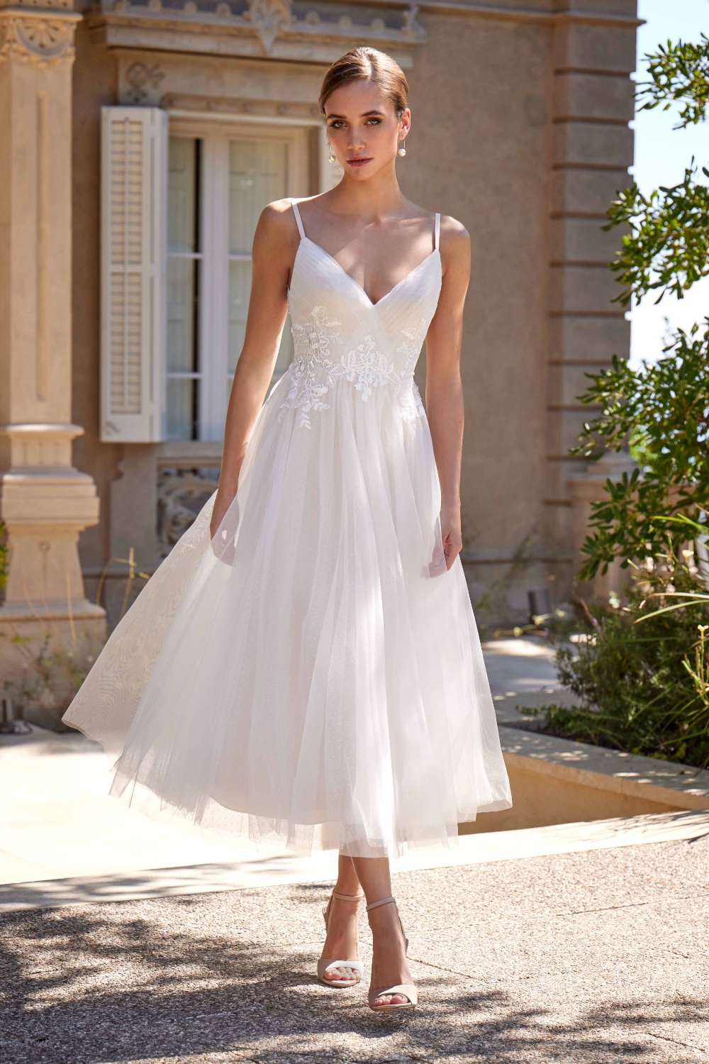 La robe de mariée civile Lise incarne à la perfection l’élégance discrète et le raffinement d’une mariée moderne. Idéale pour une cérémonie civile ou un mariage intimiste, elle séduit par sa silhouette aérienne et sa simplicité sophistiquée. Son décolleté en V délicat, soutenu par de fines bretelles, met subtilement en valeur le buste avec féminité et légèreté. Le haut de la robe, délicatement orné de broderies florales, apporte une touche romantique tout en structurant la silhouette avec finesse. La jupe midi en tulle fluide dévoile un tombé vaporeux et gracieux, offrant un mouvement naturel à chaque pas. Cette longueur, à la fois moderne et élégante, en fait une pièce idéale pour une mariée qui souhaite allier confort, style et modernité. Le dos légèrement échancré, agrémenté de détails en dentelle et d’une rangée de boutons, ajoute une finition subtile et précieuse, révélant toute la délicatesse de cette création. Lise est la robe parfaite pour une mariée à la recherche d’une robe de mariée courte ou midi, chic et intemporelle, adaptée à une mairie, un brunch de mariage ou une cérémonie en extérieur.