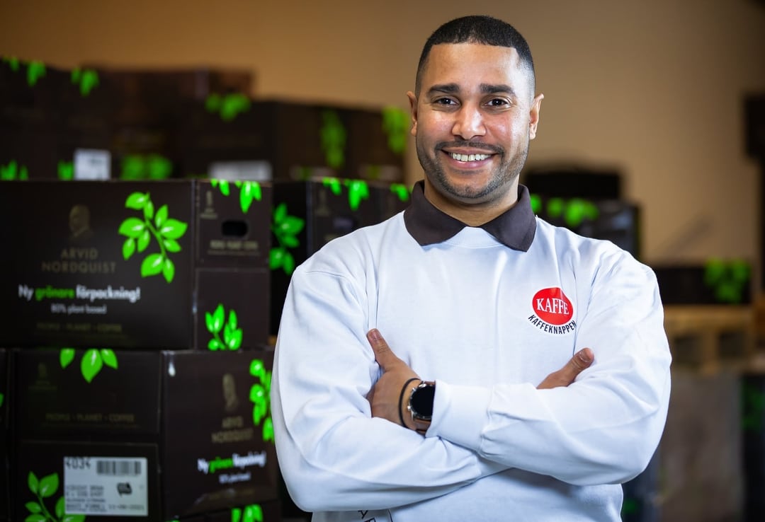 Smilende medarbeider fra Kaffeknappen foran kaffelageret