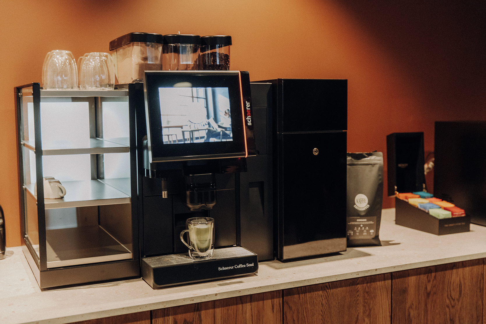 Schaerer Coffee Soul med en melkedrikk i glass, i showroomet til Kaffeknappen