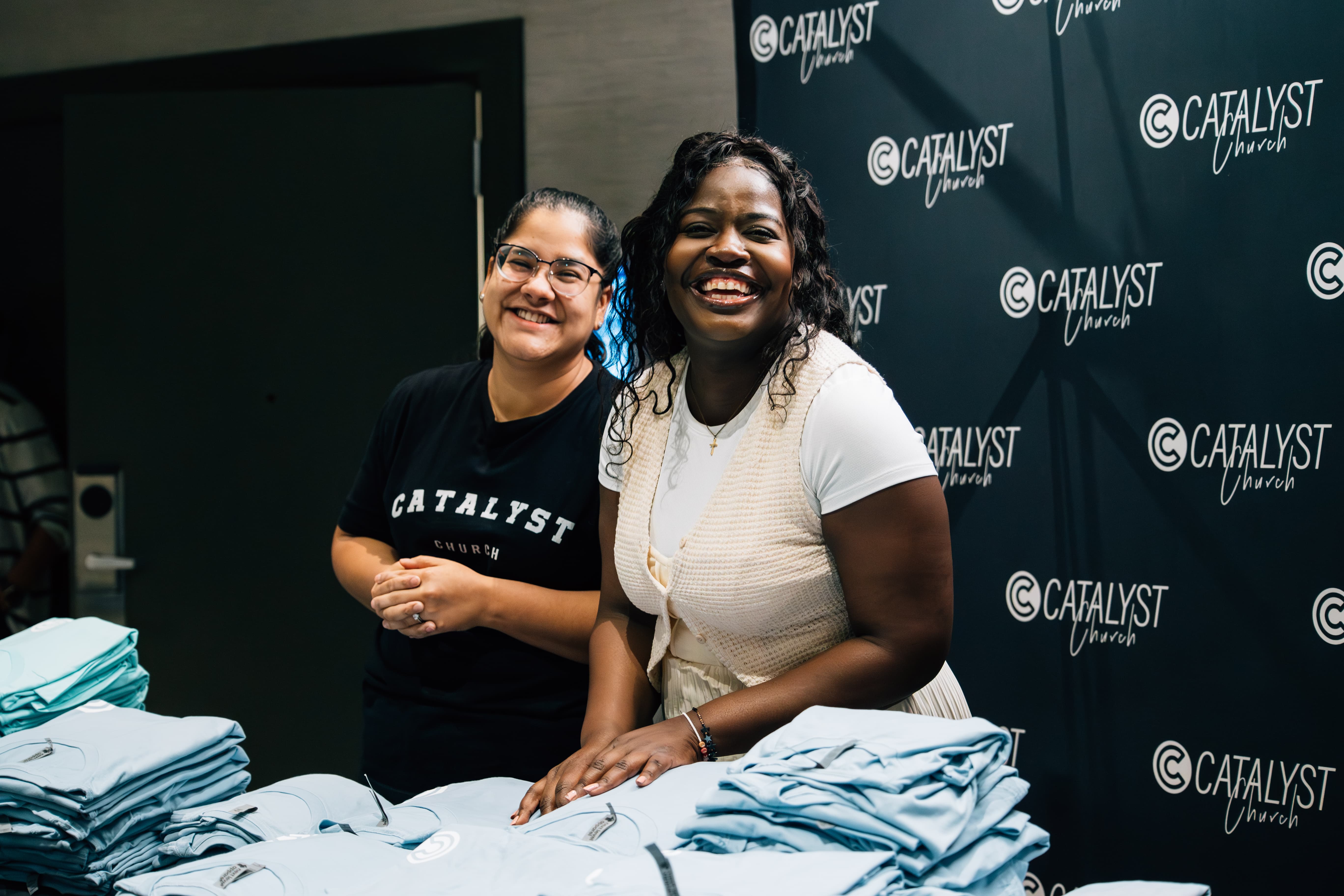 a photo of Catalyst team members carrying a table and hand sanitizer