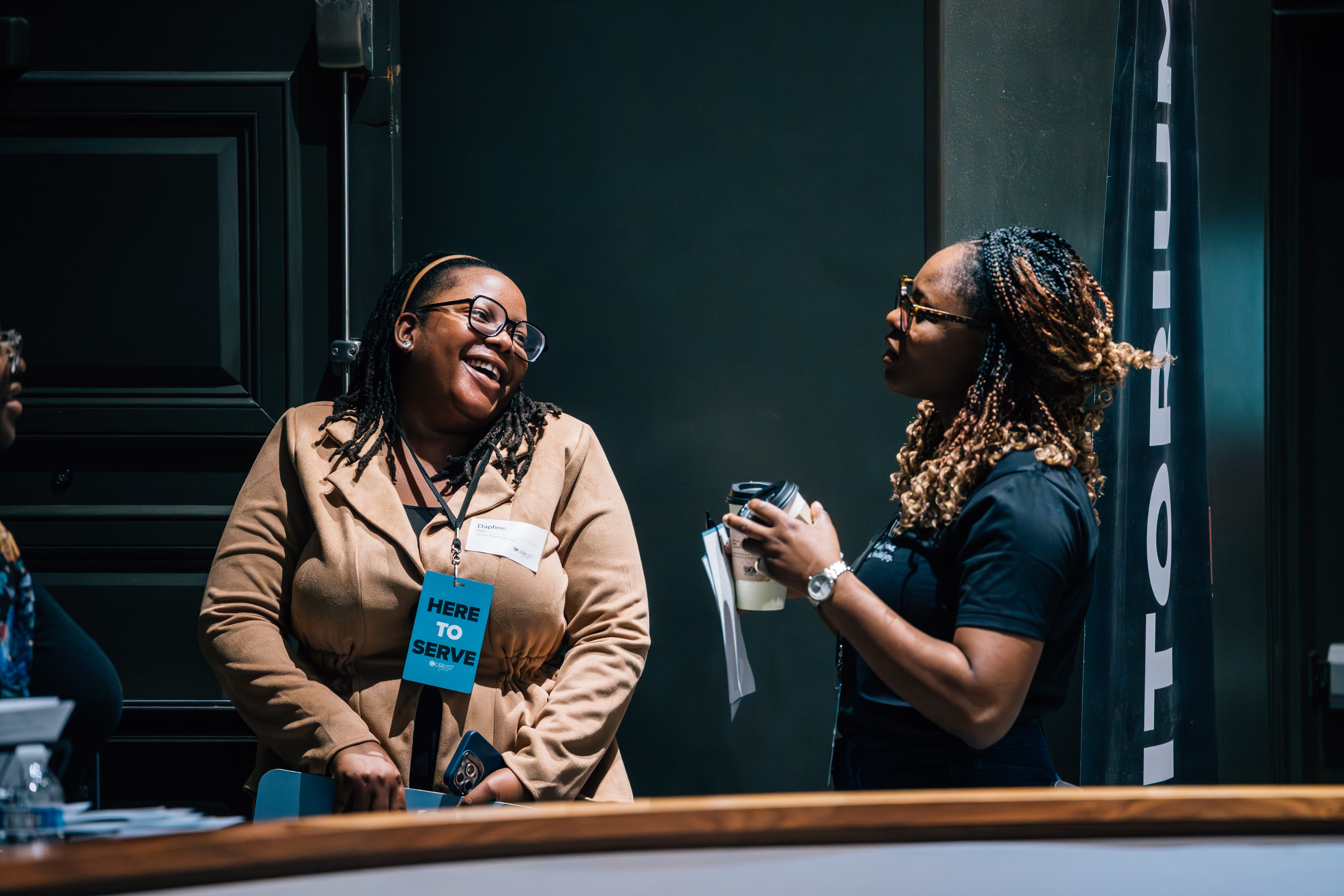 A photo of a young women from catalyst holding a welcome sign