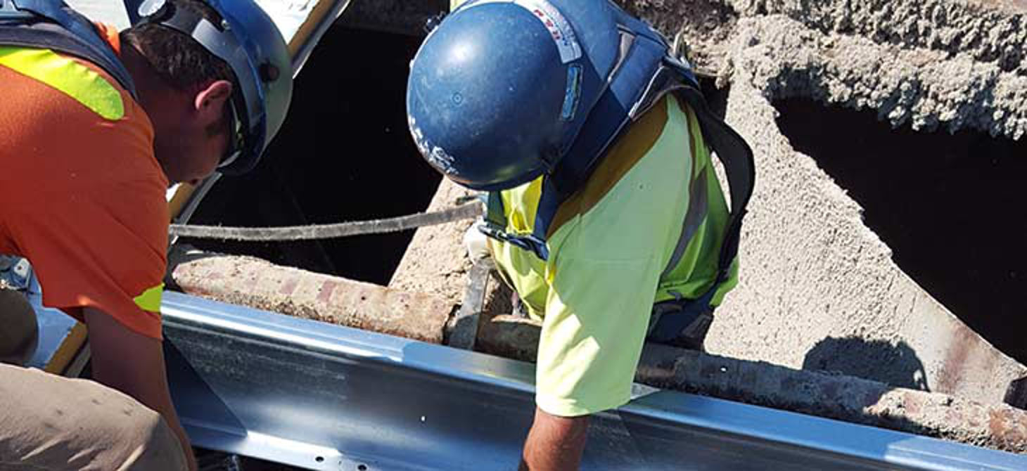 workers repairing damage to roof structure following a storm