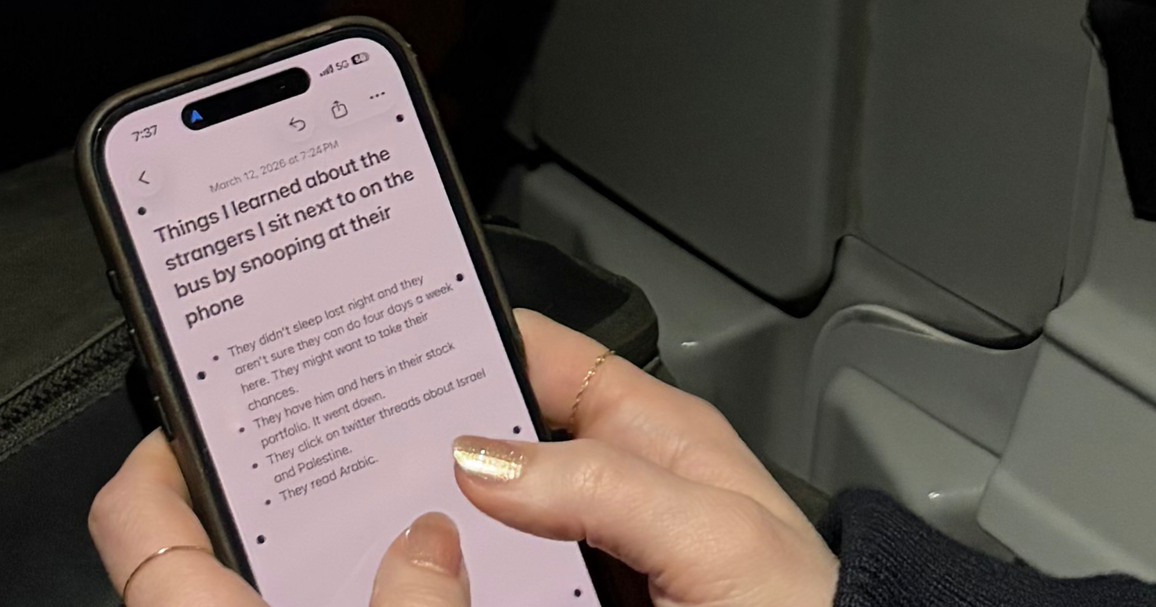 Holding an iPhone on the bus, which is open to a notes app. The headline on the note reads "Things I learned about the strangers I sit next to on the bus by snooping at their phone"