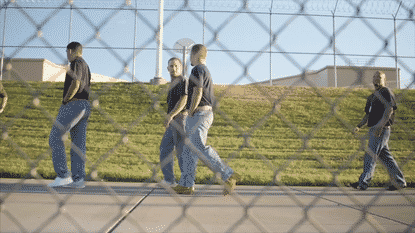 Prison inmates watching Todd Pierce share the gospel of Jesus Christ while training a horse