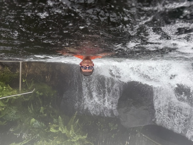 Drinking a pina colada in the hot springs, flashing a peace sign