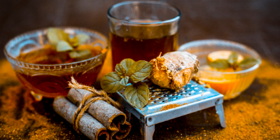 Glass tea cups and spices displayed on table dusted with turmeric powder