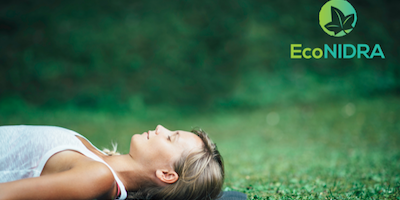 woman lying on yoga mat in grass with eyes closed