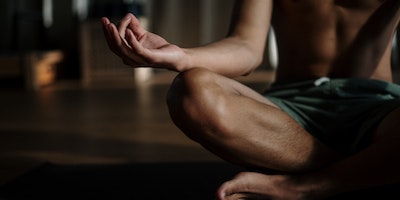 man sitting meditating dark room