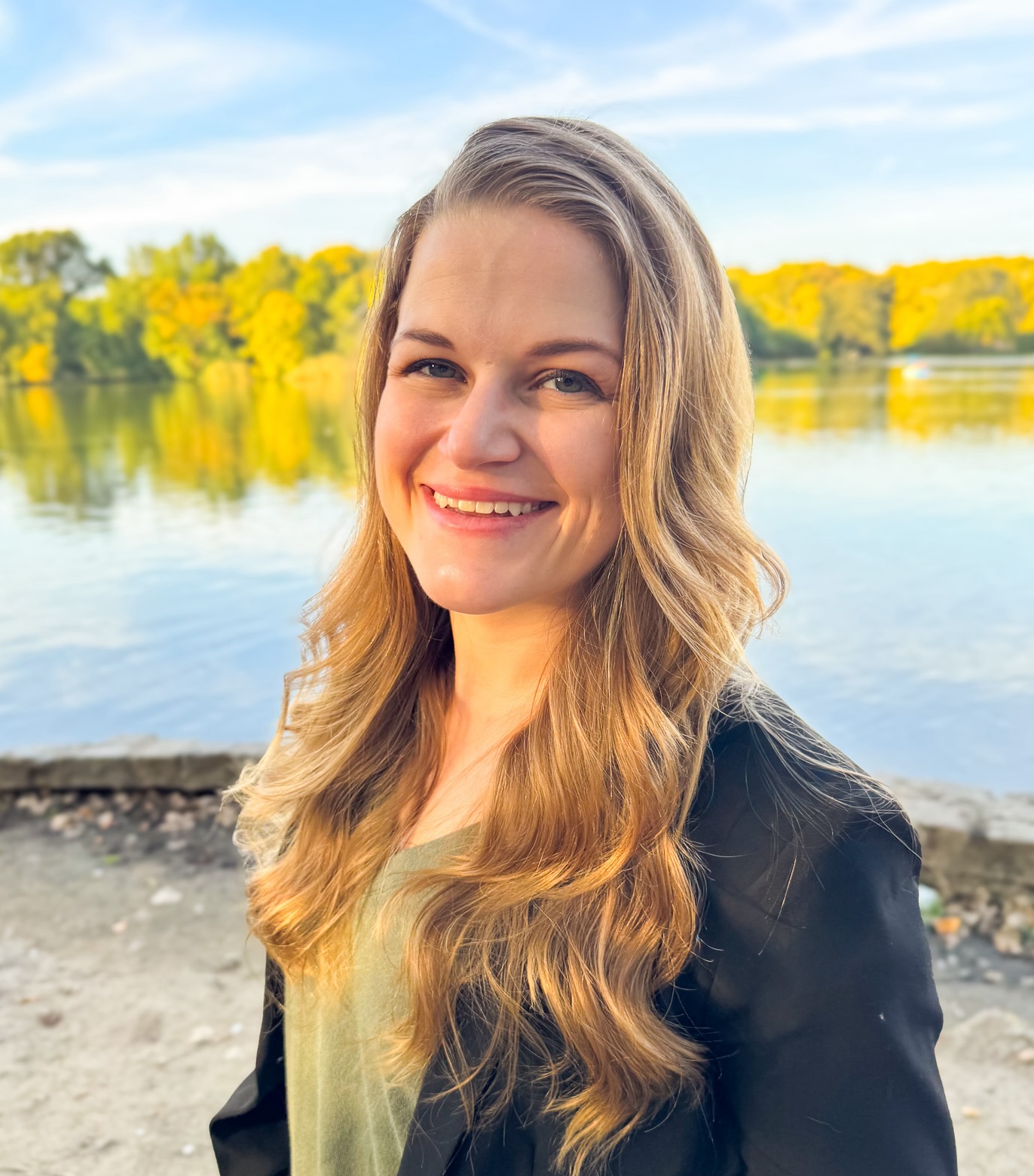 black and white headshot photo of a smiling young woman with long hair wearing a black turtleneck and a cardigan