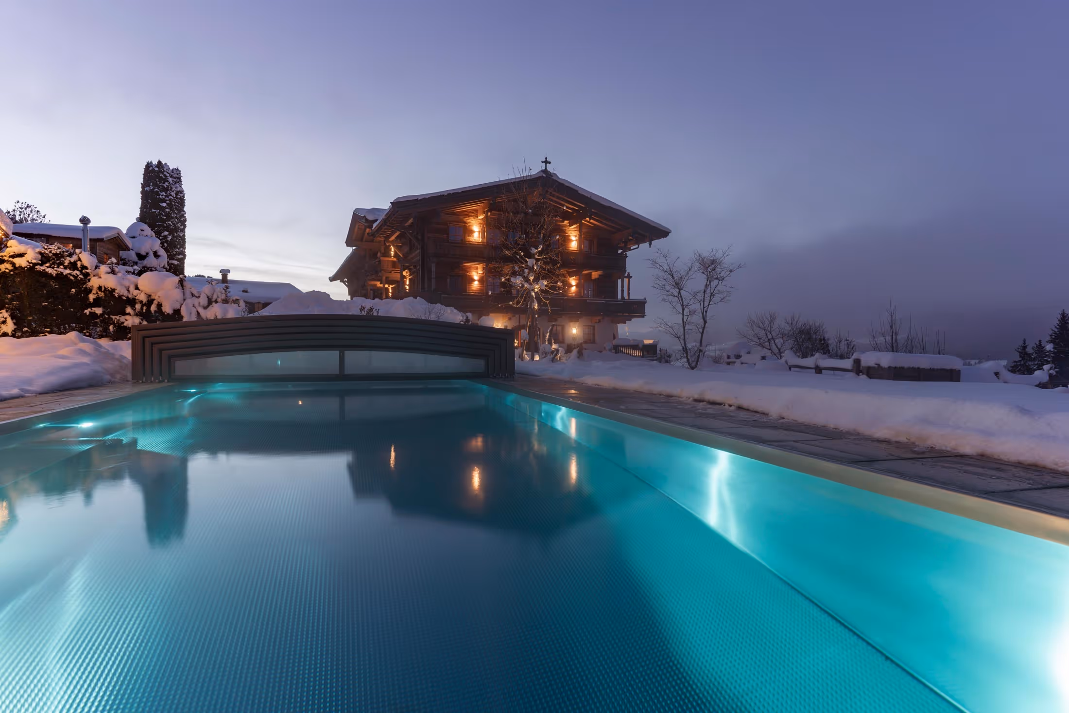 Der Naschberghof mit Outdoorpool im Winter.