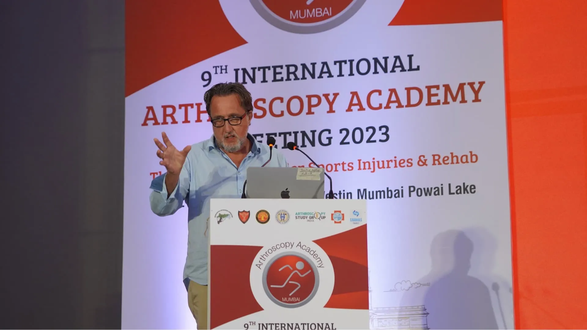 Foto von Dr. Olaf Beck am Rednerpult auf dem International Arthroscopy Academy Meeting 2023 in Indien 