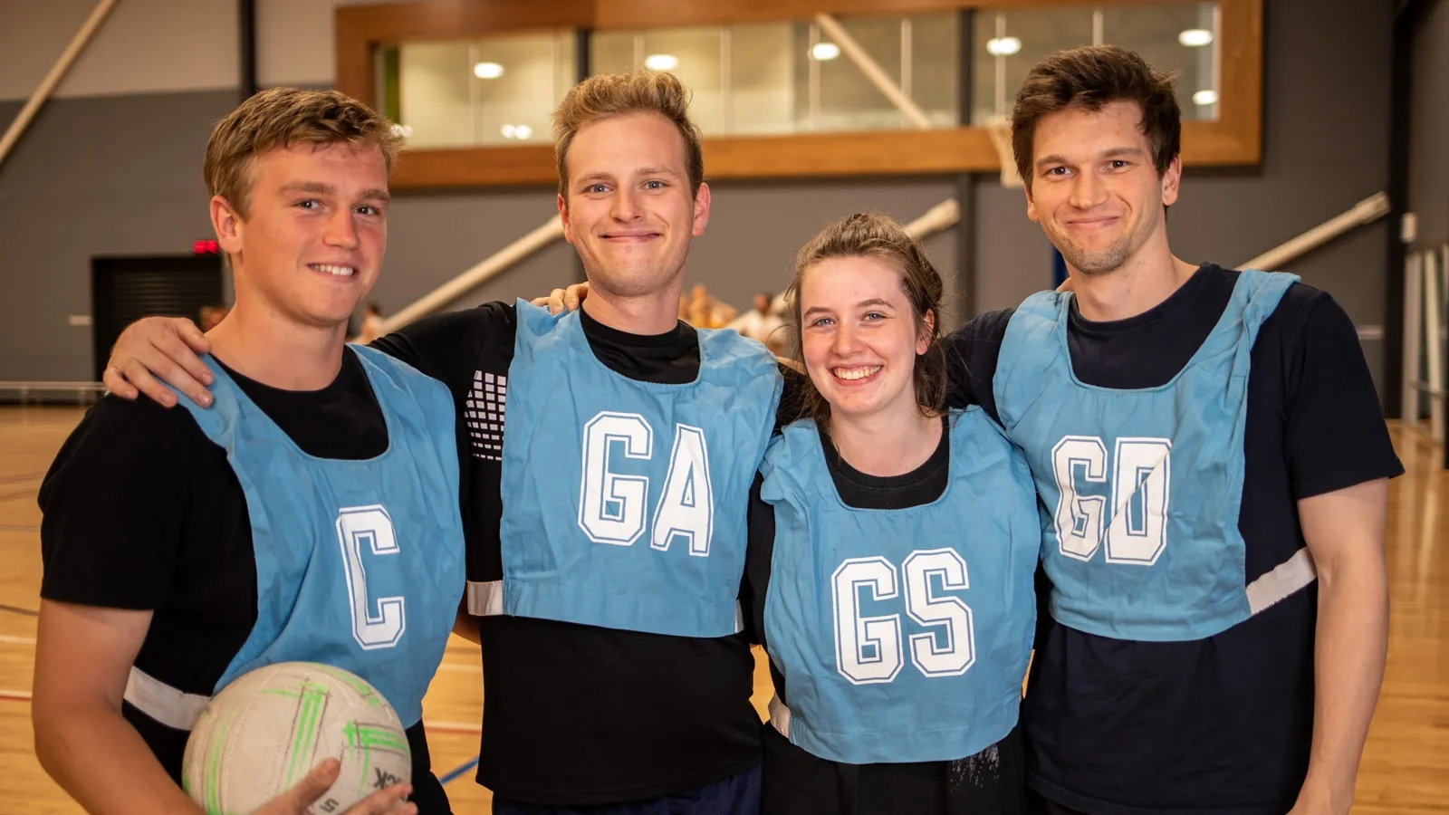 Four social Netball players stand on the side of the court
