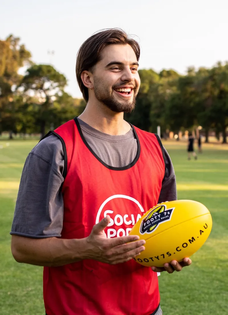 Male Footy 7s player stands with the ball