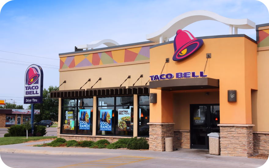Taco Bell fast-food restaurant exterior with front signage and drive thru in the US.