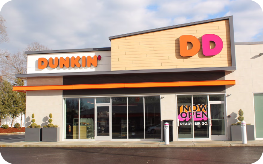 Dunkin’ store exterior with pink-and-orange branding, representing a major US coffee and bakery franchise.