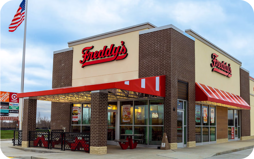 Freddy’s storefront with red awnings and classic branding, representing a growing US fast-casual franchise.