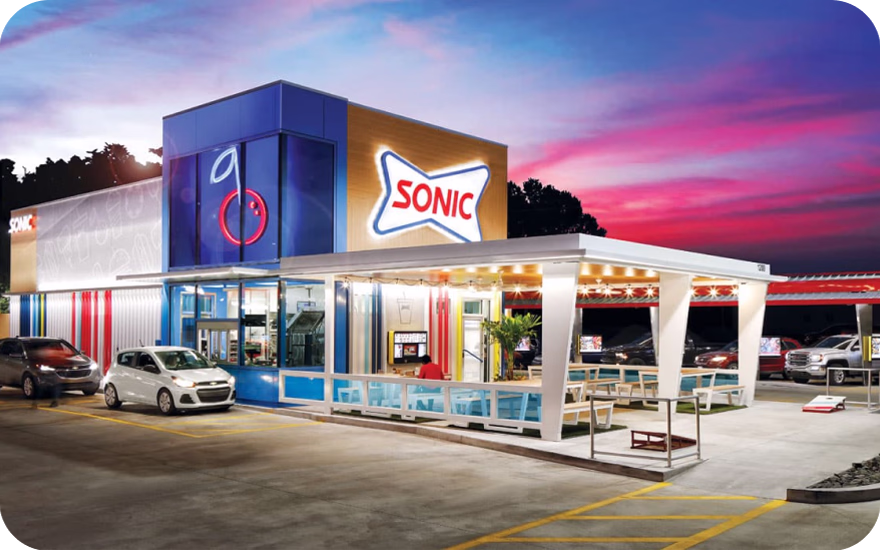 Sonic Drive-In restaurant exterior with carhop service, digital menu boards, and slush machine signage in the US.