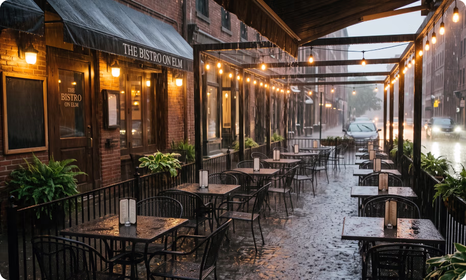 An empty bistro patio during a rainstorm.