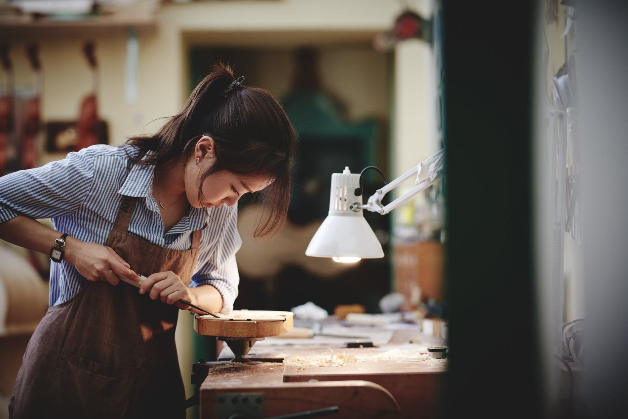 Anna Arietti in her workshop makng a violin