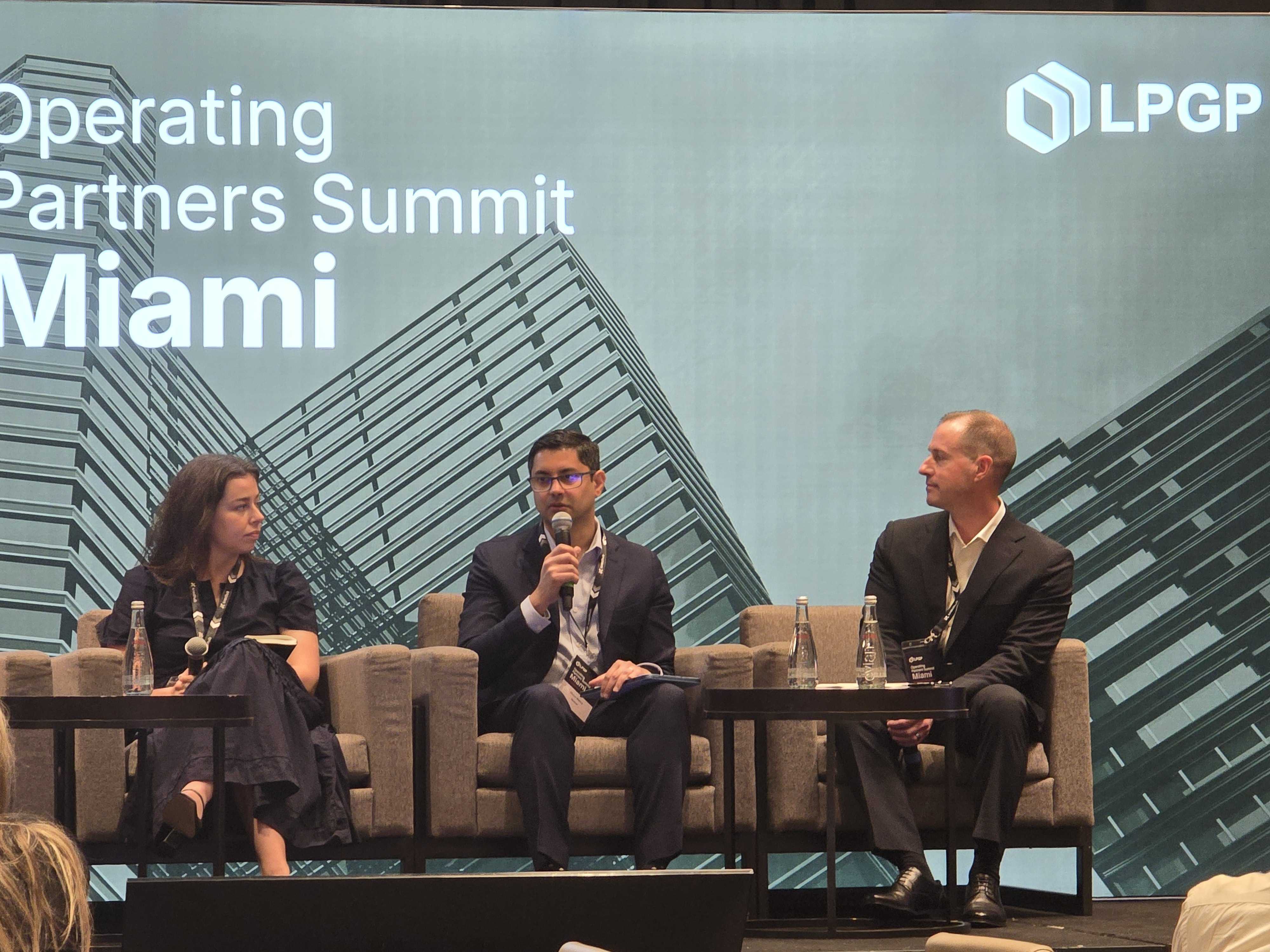 Three panelists seated in armchairs on stage at Operating Partners Summit Miami, with cityscape background and LPGP logo.