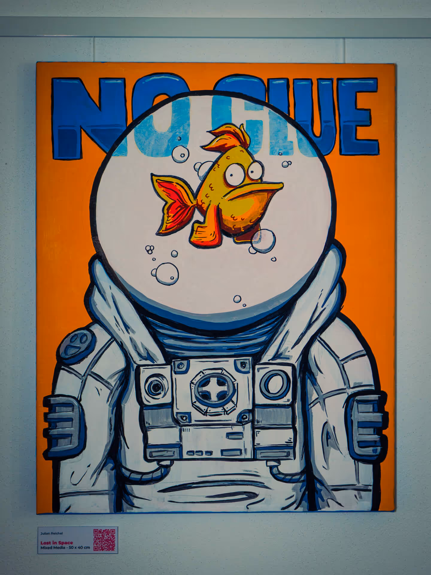 Bild aus der Serie "To Whom it may Concern" von Julian Reichel mit dem Titel Lost in Space - Fish. Es ist darauf ein Goldfisch zu sehen, der in einem weißen Raumanzug schwimmt. Hinter Ihm steht der Schriftzug "No Clue"