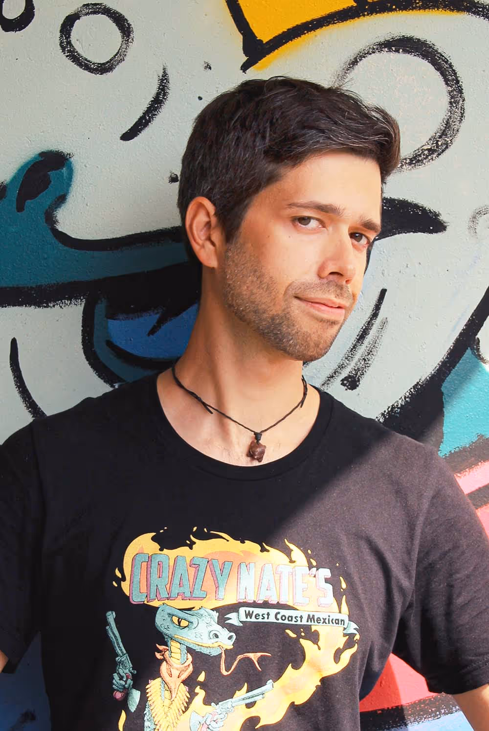 Ein Portraitbild von Julian Reichel in einem von ihm gestalteten Schwarzen T-Shirt