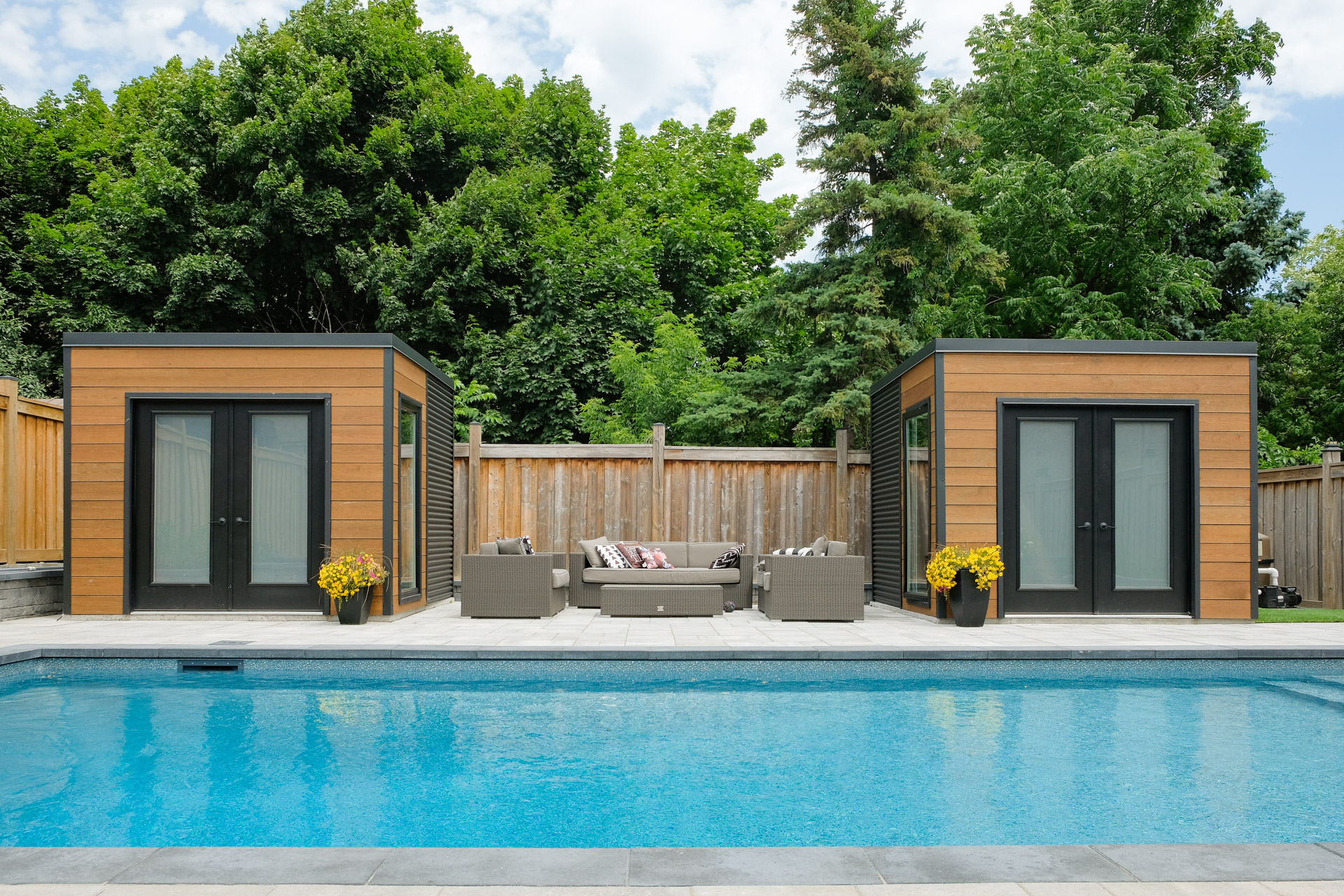 Two modern cube sheds with double French doors by the pool