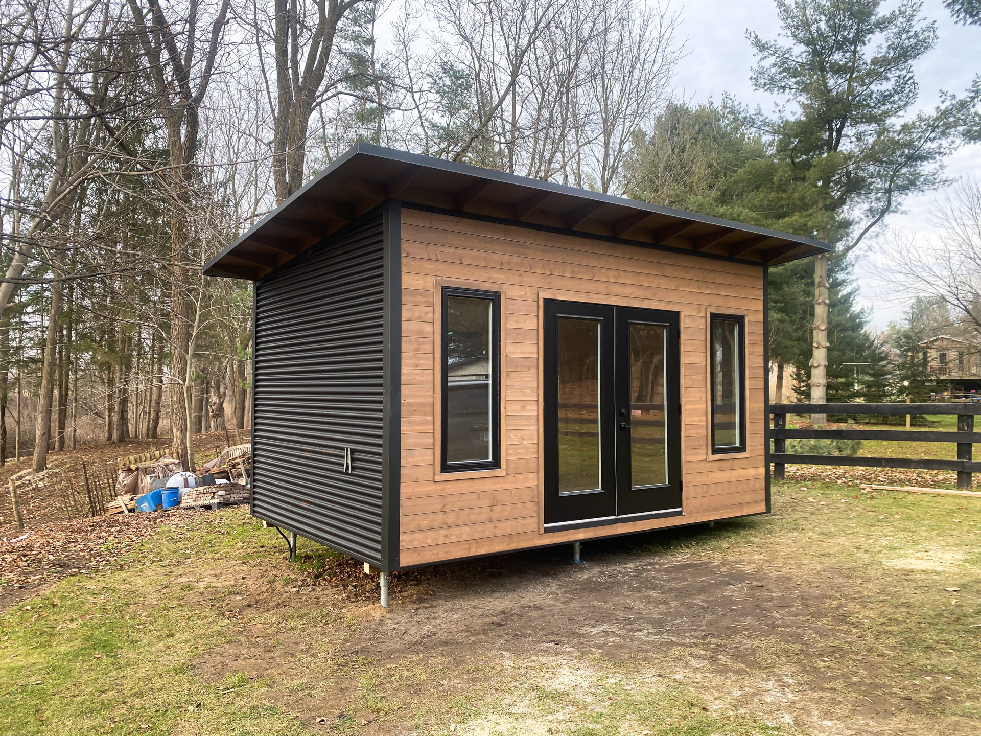 Side view of 16x10 Advanced Studio in London Ontario showing cedar front and black corrugated steel siding