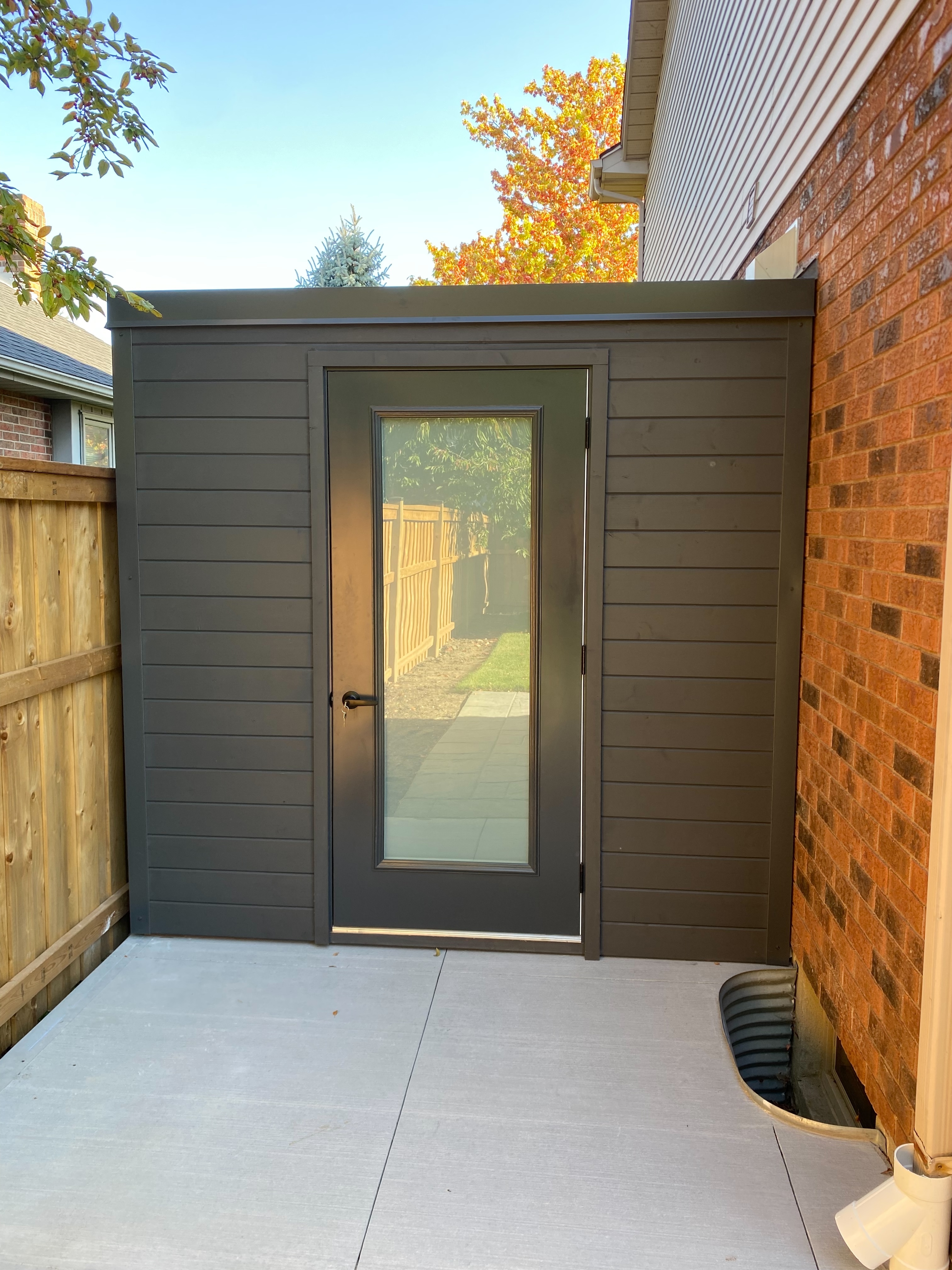 8x12 Cube Shed with Iron Ore corrugated steel siding, pine front wall, and frosted glass outswing door installed in London Ontario.