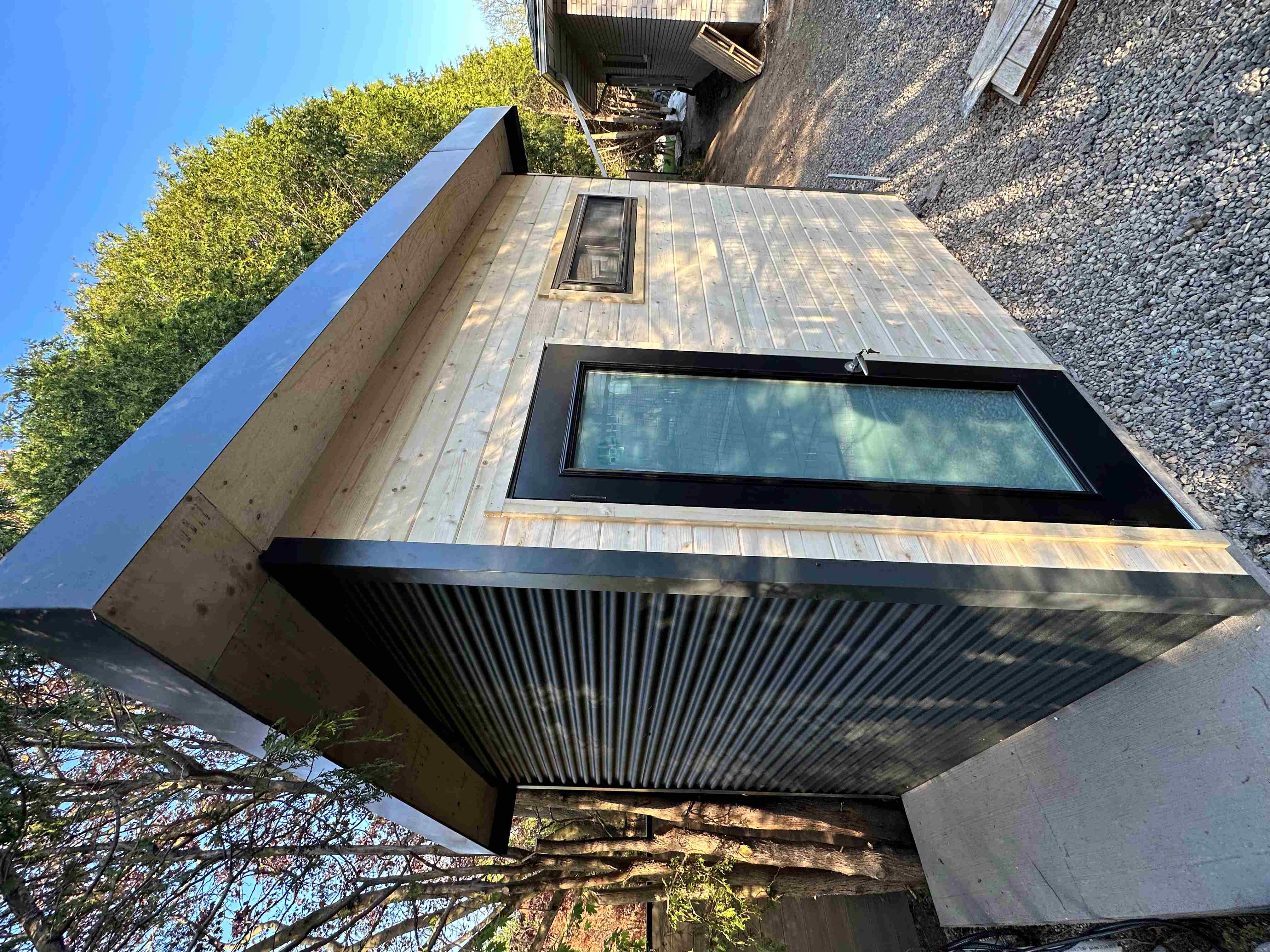 hree-quarter view of 10x7.5 Suburban Shed showing Iron Ore corrugated steel side wall, sloped SAM membrane roof with enclosed soffits, and concrete pad base in Guelph Ontario by Backyard Escape Studios.