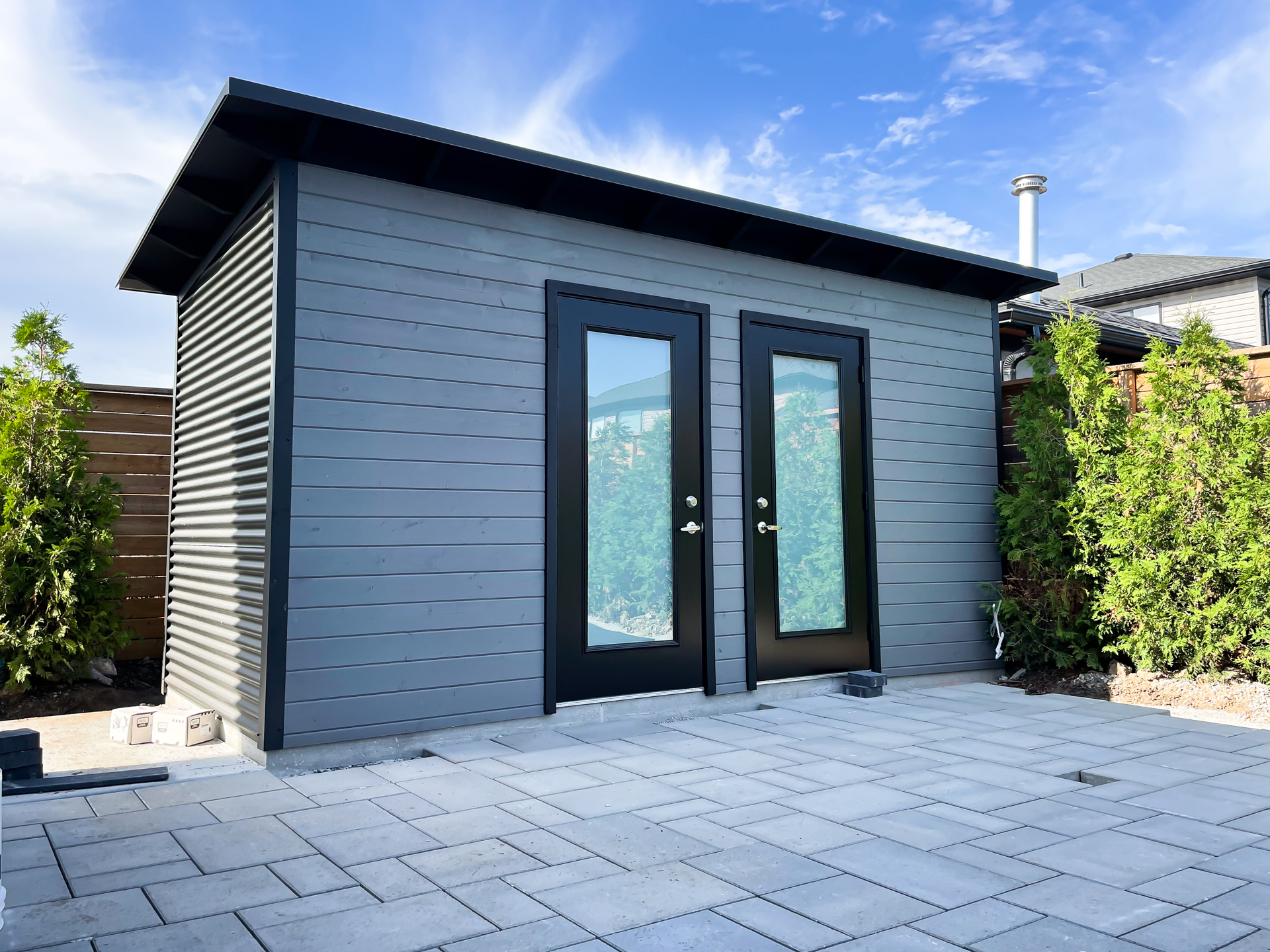 16x6 Essential pool shed with interior dividing wall for a changing room and pool equipment storage, Jet Black corrugated steel siding, Kendall Charcoal pine front, and two full-glass frosted outswing doors installed in London Ontario by Backyard Escape Studios.